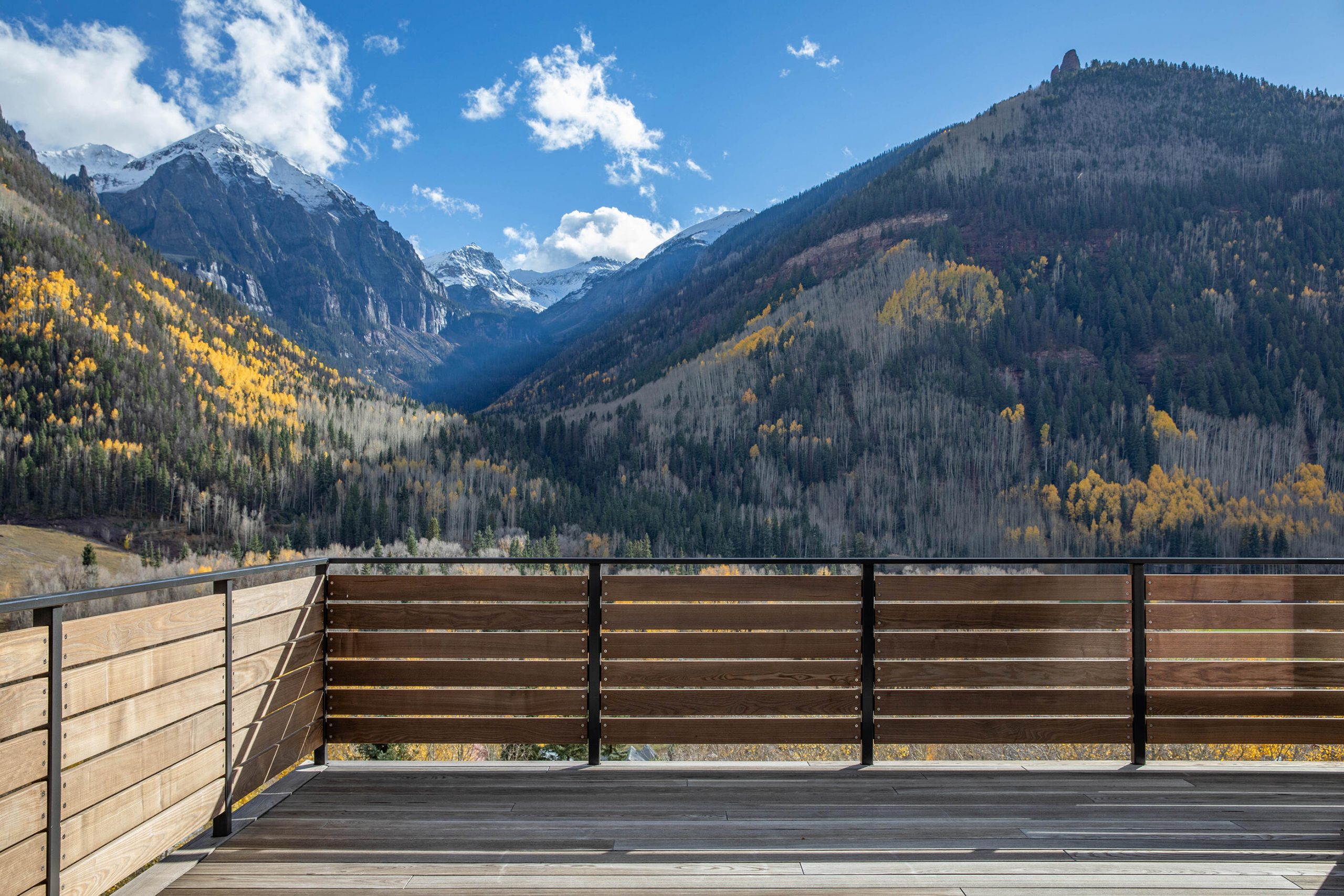 Panoramic deck view from the L19R residence in Telluride, Colorado, featuring contemporary mountain architecture and a direct southern vista of the Bear Creek Valley.