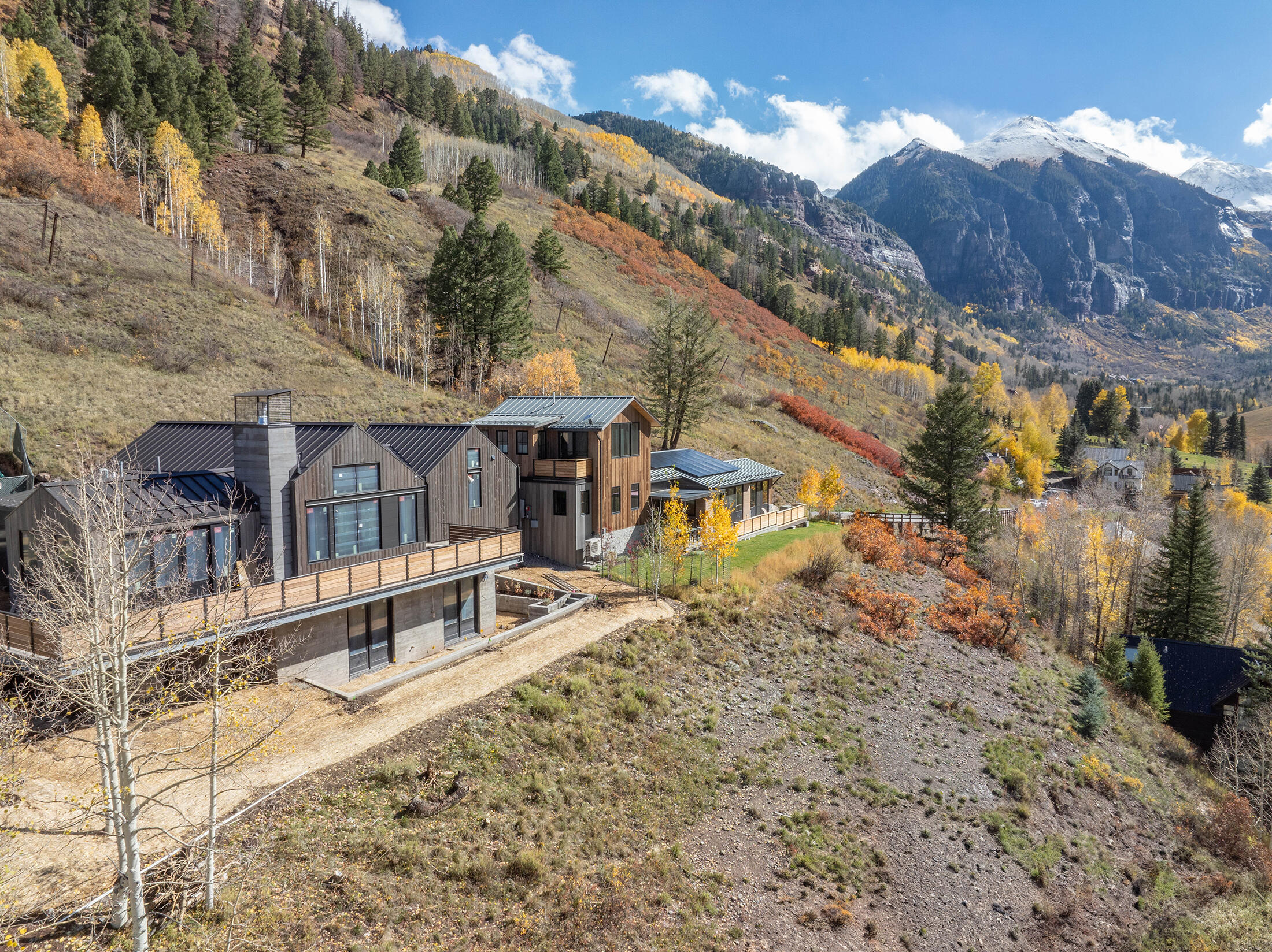 Exterior view of a newly completed contemporary residence by de alva architects llc at The Overlook in Telluride, featuring West views of the box canyon of Telluride.